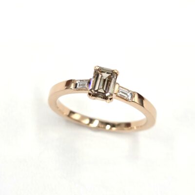 bague de fiançailles en or rose composé d un diamant taille émeraude couleur cognac et de deux baguettes