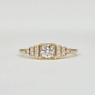 Bague en or jaune avec diamant central serti clos et pavage de diamants sur gradins