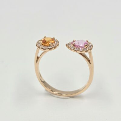 Bague ouverte en or rose avec deux saphirs de couleurs différentes sertis de diamants.