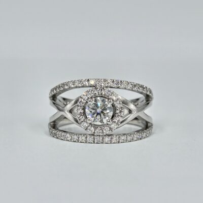 Bague en or blanc croisé avec halo de diamants et diamant central rond serti 4 griffes.