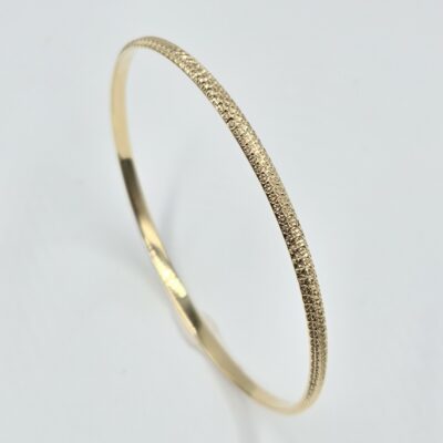 bracelet jonc rigide en or jaune 18 carats finition martelée et facettée, sans pierre